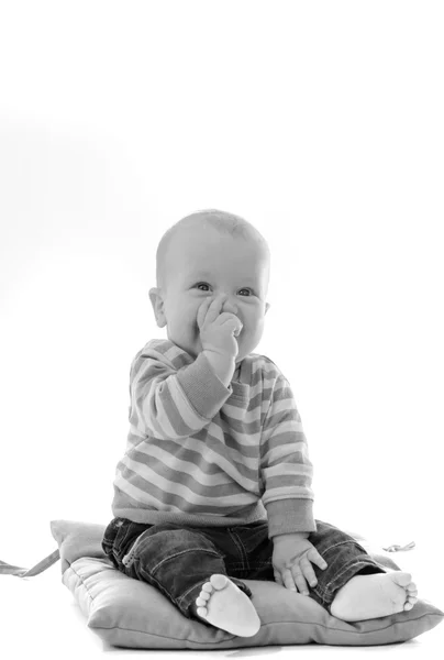 Doux garçon bébé manger son doigt sourire assis sur vert oreiller isol — Photo