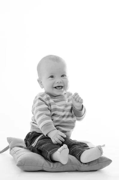 Doux garçon bébé souriant assis sur un oreiller vert isolé sur blanc b — Photo