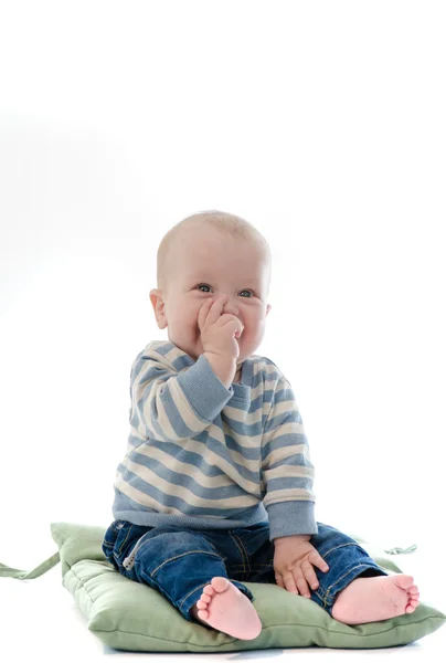 Doux garçon bébé manger son doigt sourire assis sur vert oreiller isol — Photo