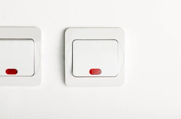 Interruptor de luz branca ligado / desligado na parede branca com led vermelho — Fotografia de Stock