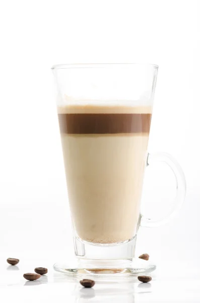 Latte macchiato com grãos de café isolados em fundo branco — Fotografia de Stock