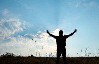 Shadow of man worship with hands raised to the sky in nature wit clipart