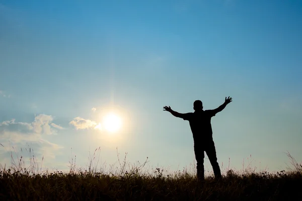 Silhouette of man worship with hands raised to the sky in nature — Stock Photo, Image