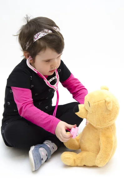 Meisje van de arts een teddybeer raadpleging — Stockfoto