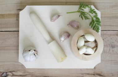 Sarımsak ve maydanoz yaprakları üzerinde izole ahşap