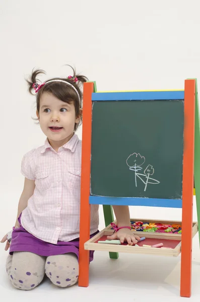 Sorprendida niña dibujar flores en el tablero negro con tiza —  Fotos de Stock