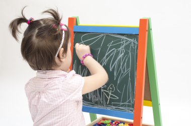 Küçük kız çizikler tebeşir yazı tahtası ile