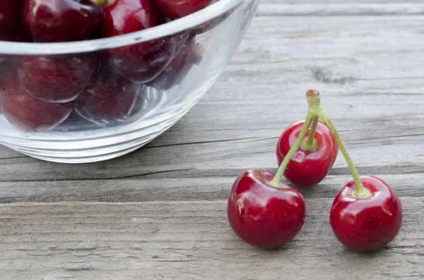 Cherries on wood and in bowl — Stock Photo, Image