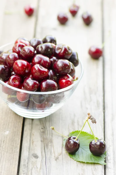 Cherries on leaf and in bowl — Stock Photo, Image