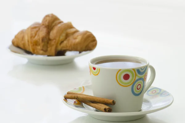 Tea in white mug with cinnamon and croissant — Stock Photo, Image