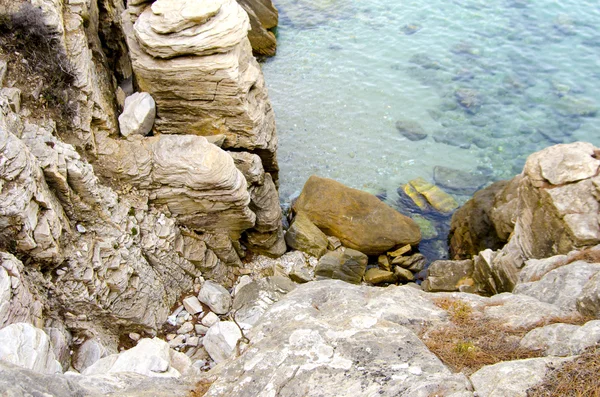 Plage rocheuse et eau turquoise claire sur la mer Égée — Photo