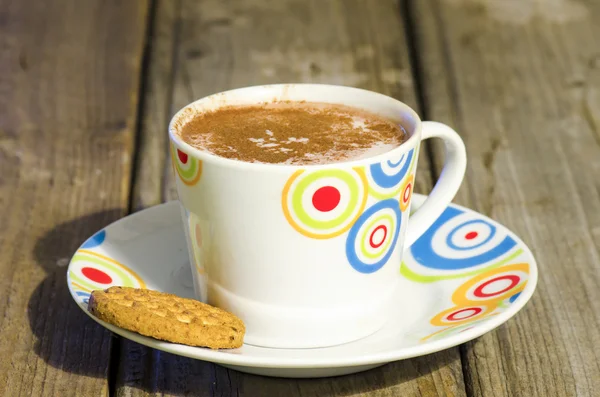 Hot chocolate with cinnamon and biscuit on wood — Stock Photo, Image