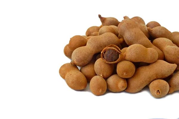 Heap of tamarind fruits on a white background.One fruit is open.
