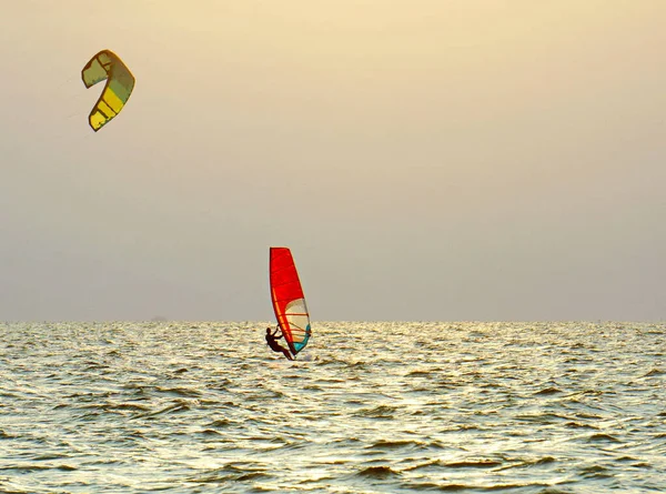 Windsurfing Morzu Czerwony Żagiel Pod Błękitnym Nieba Jest Żółty Latawiec — Zdjęcie stockowe