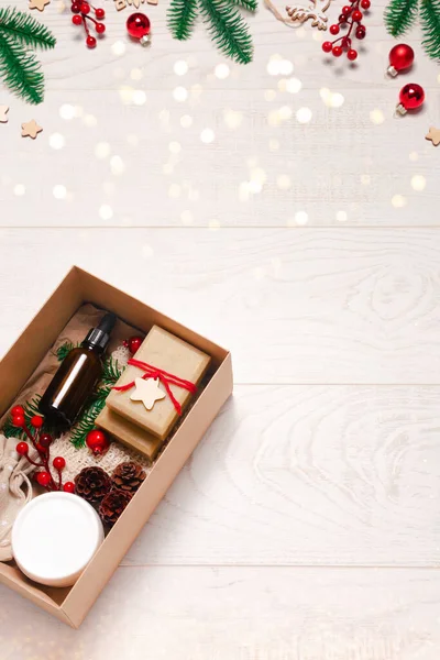Tahta arka planda dekorasyon ve ışıklarla organik eko kozmetik ürünleri olan mevcut kutu. Sıfır boşa geçen Noel ya da yeni yıl konsepti. Düz yatış, üst görünüm