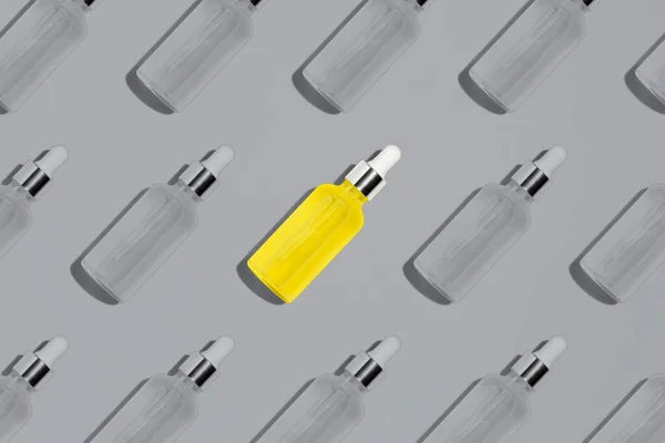 Patrón de botella de suero amarillo sobre fondo gris — Foto de Stock