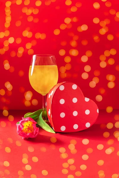 Шампанское, подарок и цветок на красном фоне Стоковое Изображение