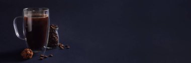 Bardakta koyu kahve, çikolatalı trüf mantarı ve koyu mavi arka planda kahve çekirdekleri. Kahvaltı konsepti. Kopyalama alanı ile ön görünüm