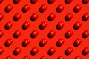 Kırmızı arka planda olgun kırmızı domatesli kusursuz sonsuz desen. Domateslerin tekrarlanan fotoğraf arkaplanı, üst görünüm.