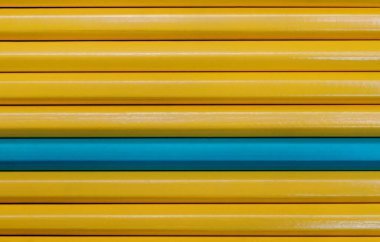 Sarı kalemler ve bir mavi kalem. Kapatın. Farklılık kavramı.