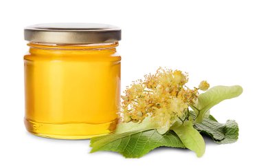 Cam kavanoz bal ve ıhlamur çiçekleri beyaz arka planda izole edilmiş yapraklarla.