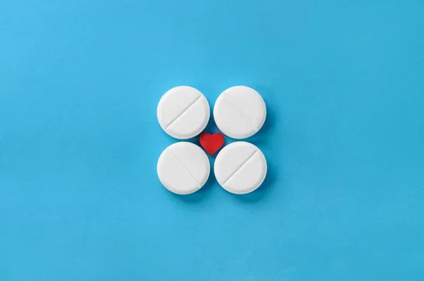 Dört Vitamin Tabletinden Kare Mavi Arkaplanda Küçük Kırmızı Kalp Üst — Stok fotoğraf