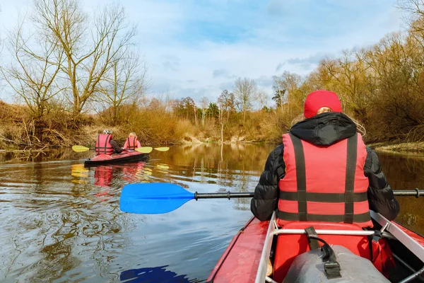 People sailing in kayaks on the river in early spring. Extreme water entertainment and active. Kayaking on the river.