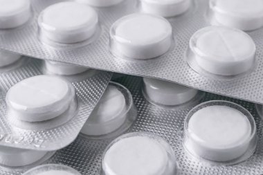 Folyo kabarcıklarındaki beyaz hapları kapat. Küçük bir odak derinliği. Eczane kavramı.