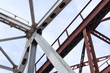 Tren köprüsünün yeni ve eski çelik yapısının bir kısmı, metal kirişleri, cıvataları ve fındıkları olan inşaat detayları..