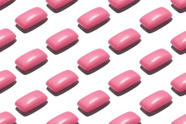 Beyaz zemin üzerinde pembe sabun çubukları olan kusursuz tekrarlayan desen.