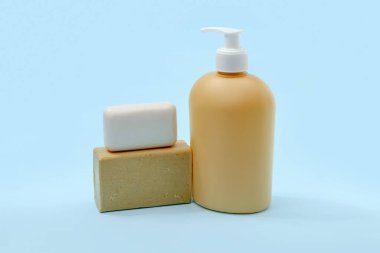 Farklı sabun barları ve pompa şişesi mavi arka planda sıvı sabun için