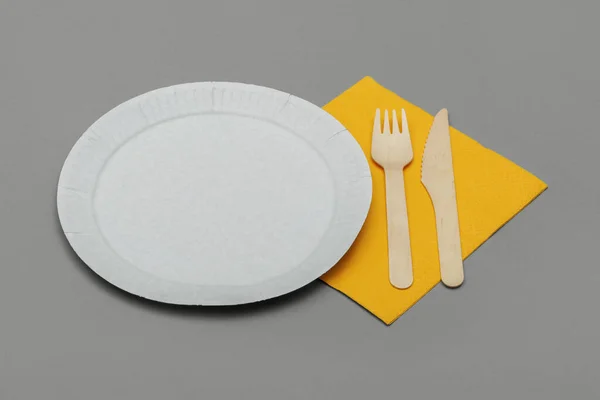 White Paper Dish Wooden Fork Knife Yellow Napkins Gray Background — Stock Photo, Image