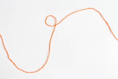 Orange thread on a piece of paper. clipart