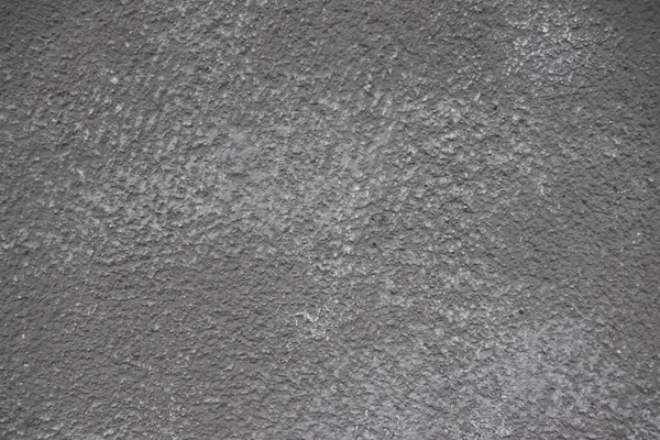 The texture of the plastered wall of the building.
