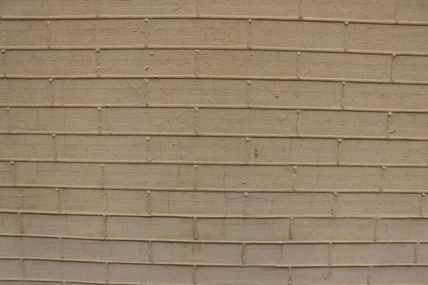 Plastered wall of a building in the form of a brick outline.