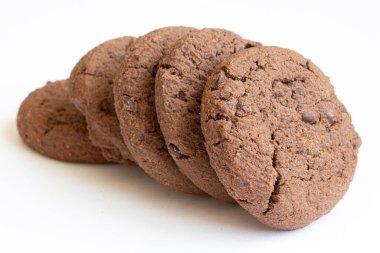 Hafif arkaplanda çikolata parçaları olan yuvarlak çikolatalı kurabiyeler..