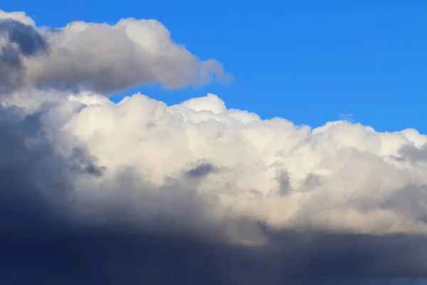 Rain gray clouds in the blue sky during the day.