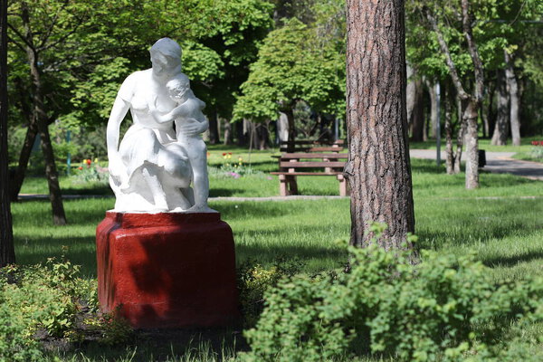 An old sculpture of a mother with a child in a park, Soviet times. 