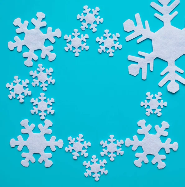 Composição de inverno de flocos de neve brancos em um contexto azul. quadro de flocos de neve com espaço de cópia — Fotografia de Stock