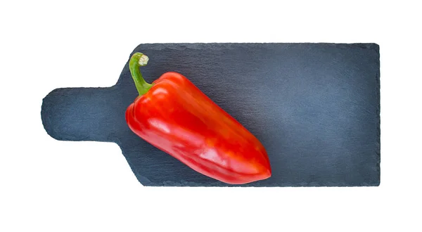 Red pepper on a cutting black board on a white background — Stock Photo, Image