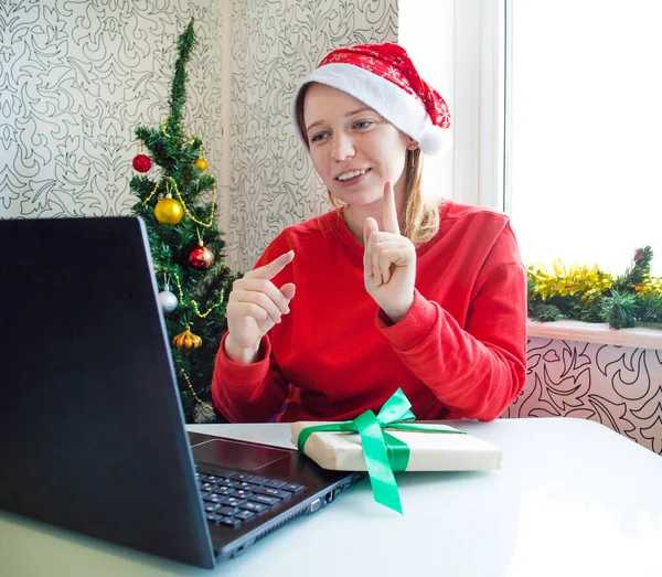 Online Noel tebriği. Genç, gülümseyen bir kadın dizüstü bilgisayarda işaret diliyle öğreniyor ve iletişim kuruyor..