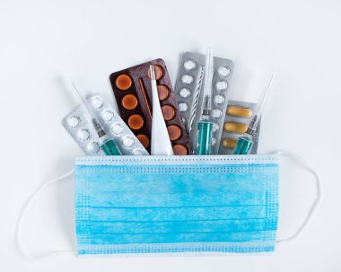 Haplar, aşı şırıngası, tıbbi maske, beyaz arka planda termometre..