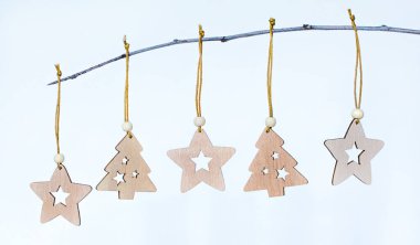 Noel için çevre dostu ahşap oyuncaklar ya da yeni yıl süslemeleri bir ağaç dalına asılı.