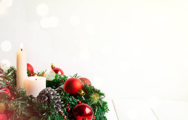 Kandil yakmak ve Noel çelengi kırmızı toplar ve beyaz üzerinde çam kozalakları