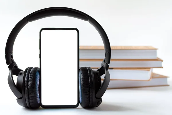 Phone and headphones in the background of books. concept choice of technology or classics. — Stock Photo, Image