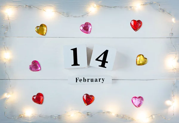Dia dos Namorados fundo com corações, guirlanda amarela e calendário bloco de madeira fevereiro 14 — Fotografia de Stock