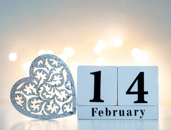 Calendário de madeira show de 14 de fevereiro com coração de madeira e bokeh dourado na parte de trás. conceito dia dos namorados. — Fotografia de Stock