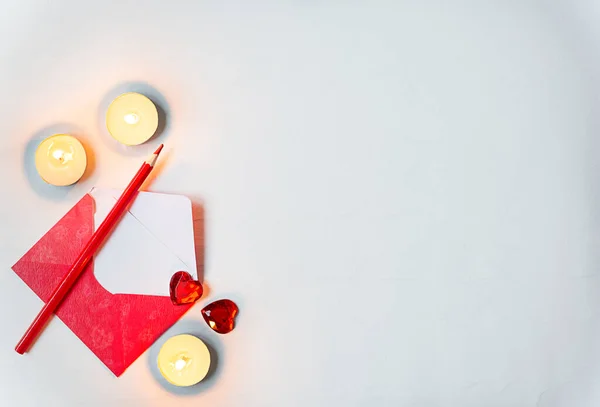 Roter Umschlag und Bleistift mit rotem Herz und Kerzen auf weißem Hintergrund mit Kopierraum — Stockfoto