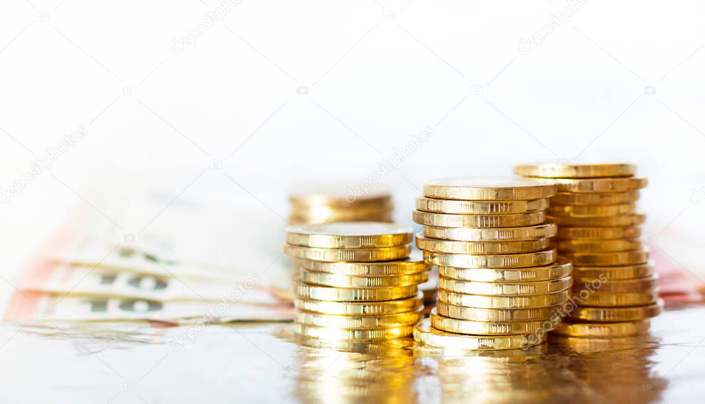 gold coins piled up and euro bills on white background.