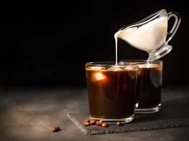 Kremalı bir bardakta buzlu kahve. Sütlü et suyu kayığı havalanır..